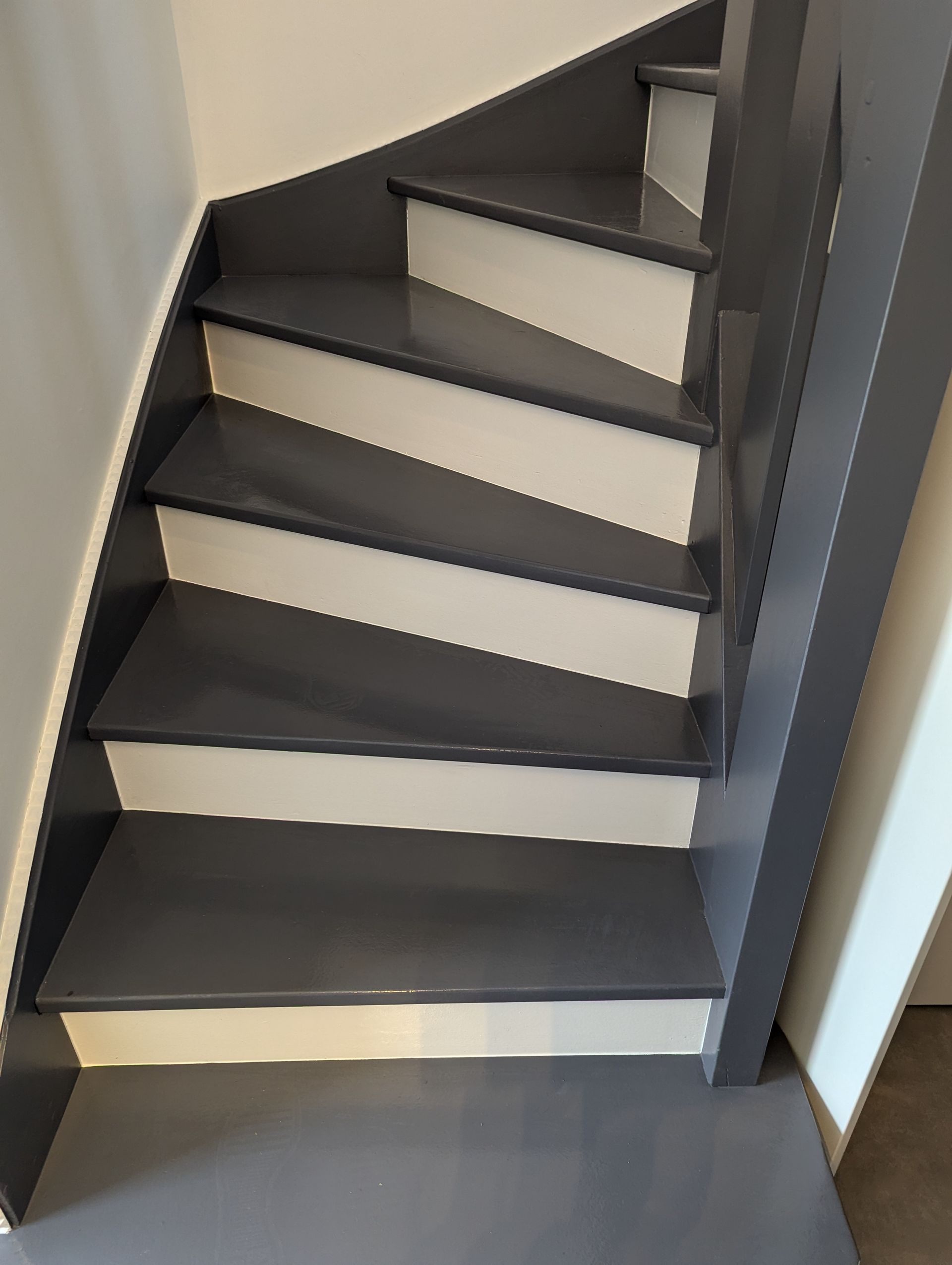 Escalier intérieur peint en gris avec contremarches blanches et rampe grise.