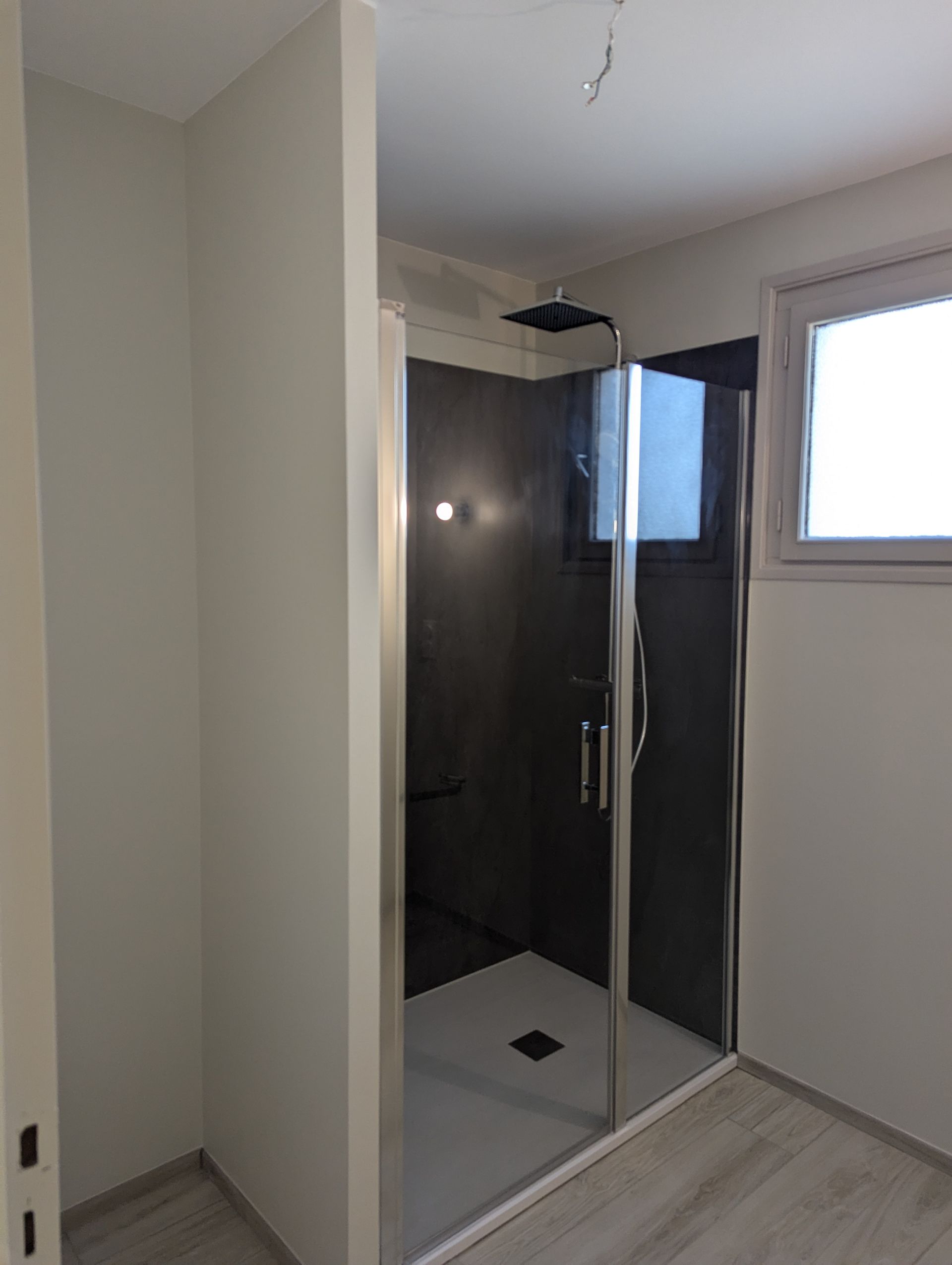 Chambre avec linge de lit violet, murs gris, grand miroir et éclairage moderne.