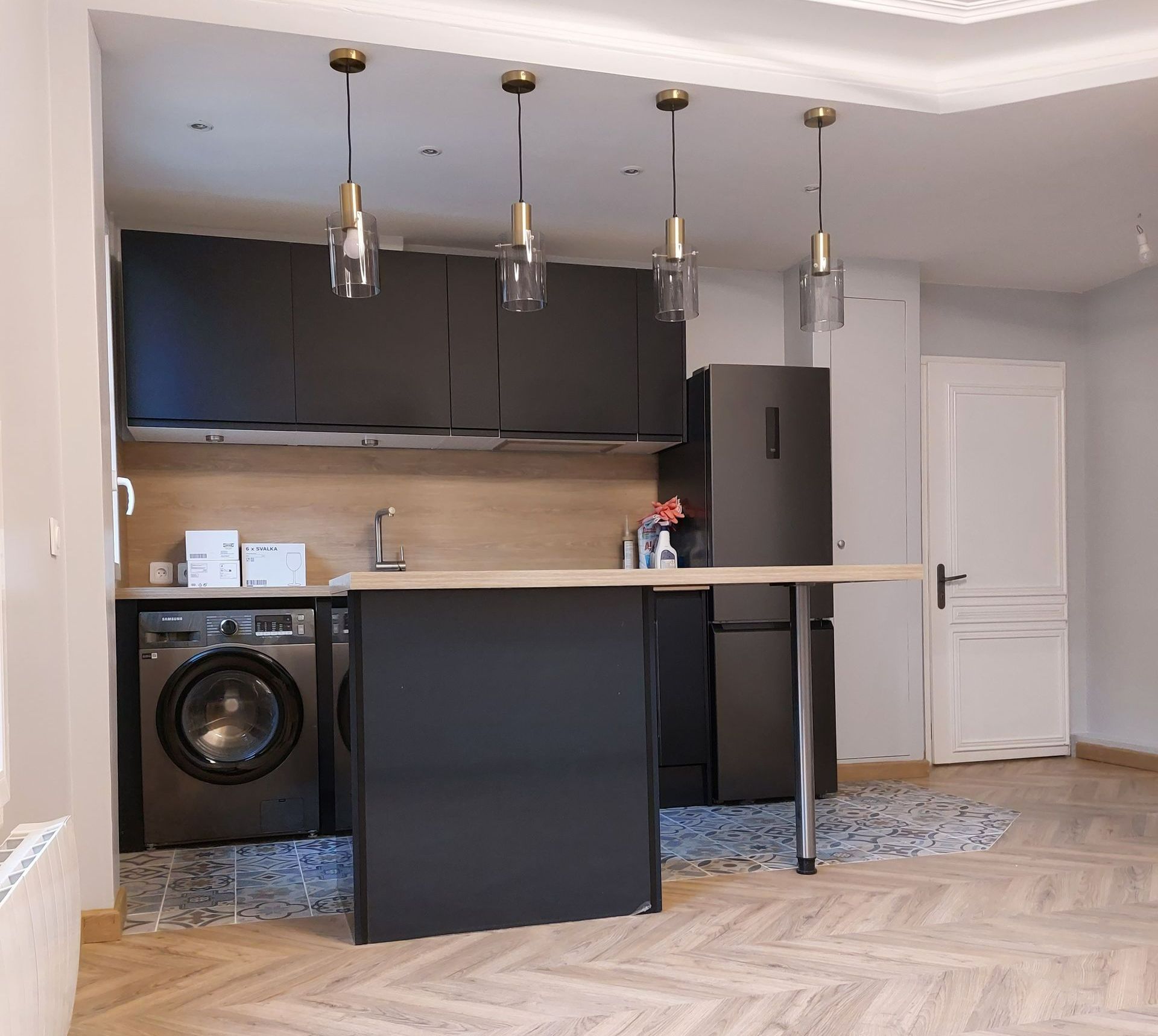 Une cuisine avec un parquet et un îlot central.