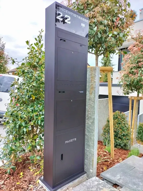 Briefkastenstele Standbriefkasten Briefkasten freistehend mit paketbox von ERCOTEH mit Videosprechanlage in Anthrazit RAL 7016 mit eingebauter Kamera und Klingel Fingerprint Codeschloss und keypad Türsprechanlage von Gira System 106, Siedle, Loxone, 2N Videosprechanlage maßanfertigung nach kundenwunsch aufputz briefkasten designer premium ercoteh briefkastenmanufaktur made in germany
