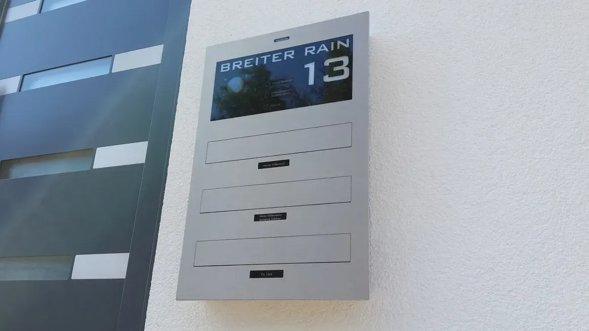 Mauerdurchwurf-Briefkasten durchwurf-Briefkasten 3-Familien von ERCOTEH mit Videosprechanlage in Anthrazit RAL 7016 Edelstahl, beleuchtete Straße und Hausnummer mit eingebauter Kamera und Klingel Fingerprint Codeschloss und keypad Türsprechanlage von Gira System 106, Siedle, Loxone, 2N, HIKVISION Videosprechanlage maßanfertigung nach kundenwunsch aufputz briefkasten designer premium ercoteh briefkastenmanufaktur made in germany set 2009