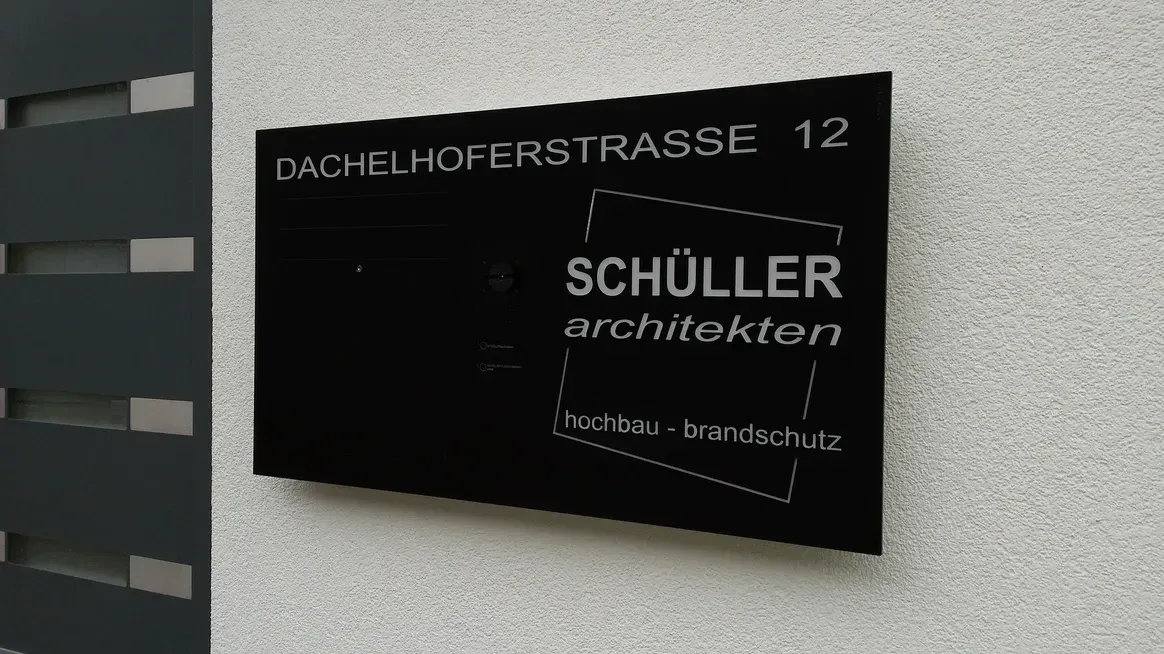 Ein Schild an der Seite eines Gebäudes mit der Aufschrift Schuller Architecten