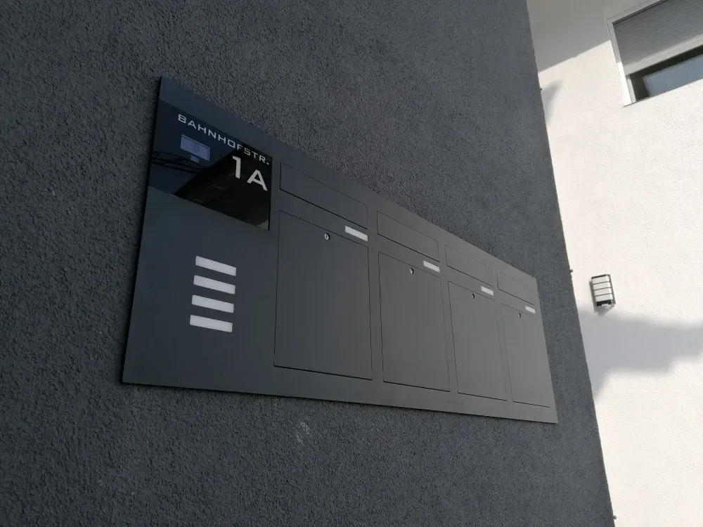 Mauerdurchwurf-Briefkasten durchwurf-Briefkasten 4-Familien von ERCOTEH mit Videosprechanlage in Anthrazit RAL 7016 Edelstahl, beleuchtete Straße und Hausnummer mit eingebauter Kamera und Klingel Fingerprint Codeschloss und keypad Türsprechanlage von Gira System 106, Siedle, Loxone, 2N, HIKVISION Videosprechanlage maßanfertigung nach kundenwunsch aufputz briefkasten designer premium ercoteh briefkastenmanufaktur made in germany set 2009