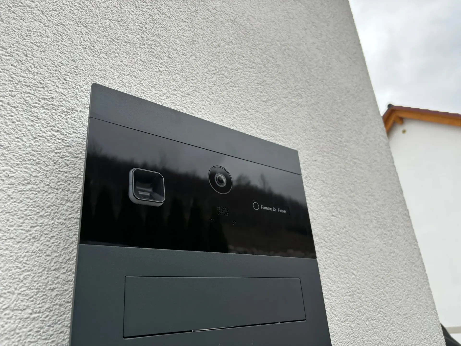 An der Seite eines Gebäudes befindet sich ein schwarzer Briefkasten.