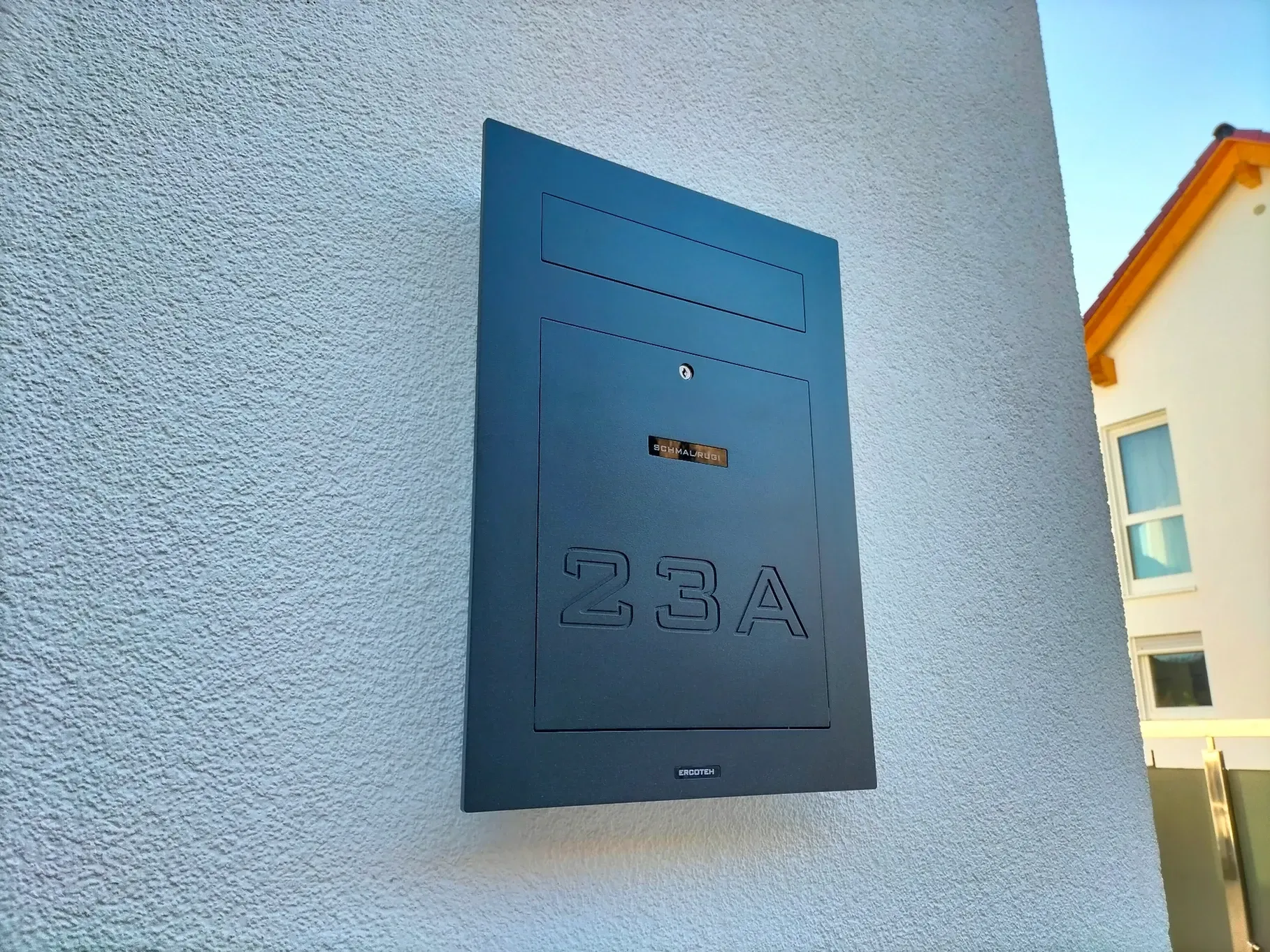 Ein schwarzer Briefkasten an der Seite eines weißen Gebäudes