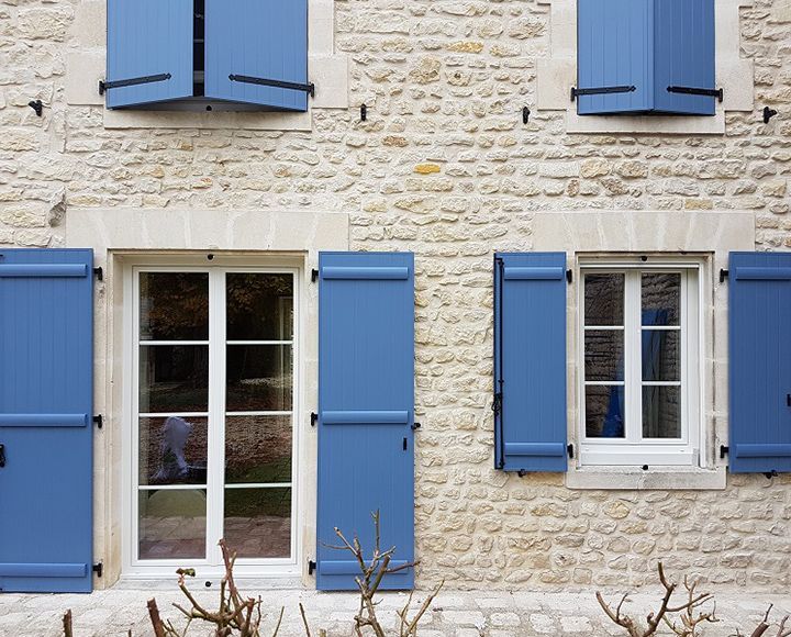 Volets en bois d'une maison avec murs en pierre