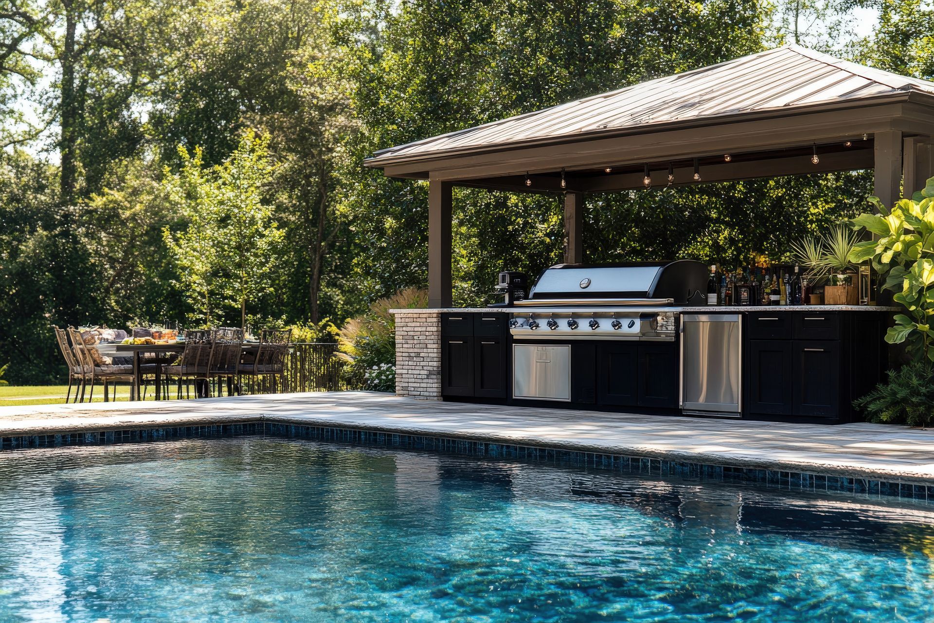 Cuisine d'extérieure en inox installée près d'une piscine