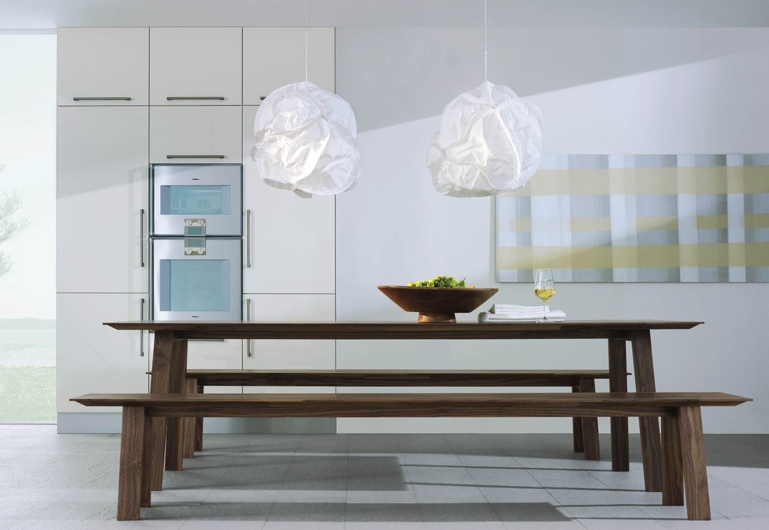 Salle à manger contemporaine avec table en bois et suspensions en verre