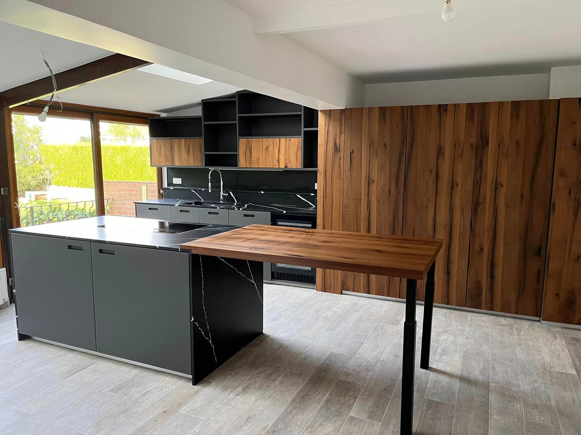 Cuisine haut de gamme avec façades bois et îlot central noir