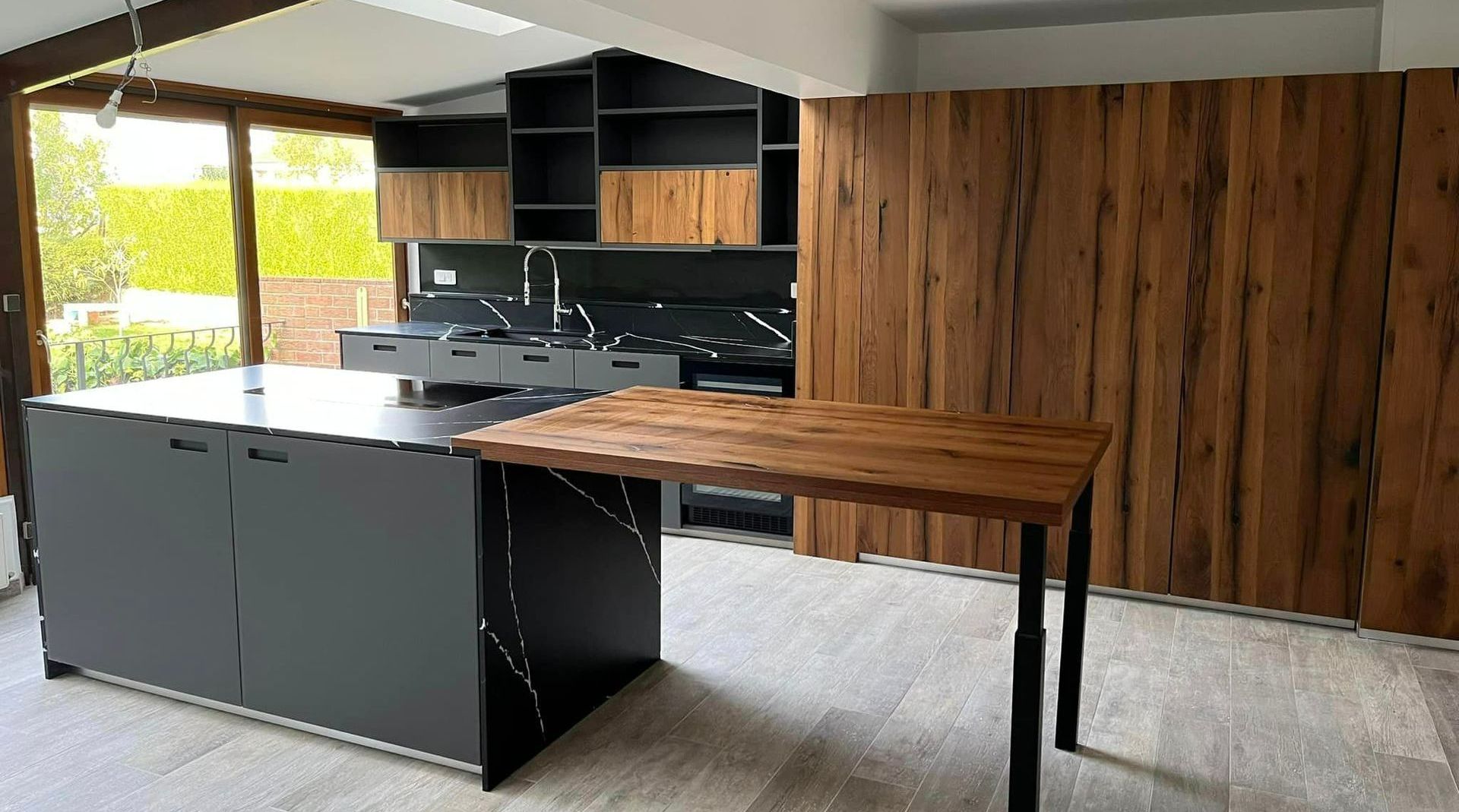 Cuisine avec îlot central et revêtements gris et bois