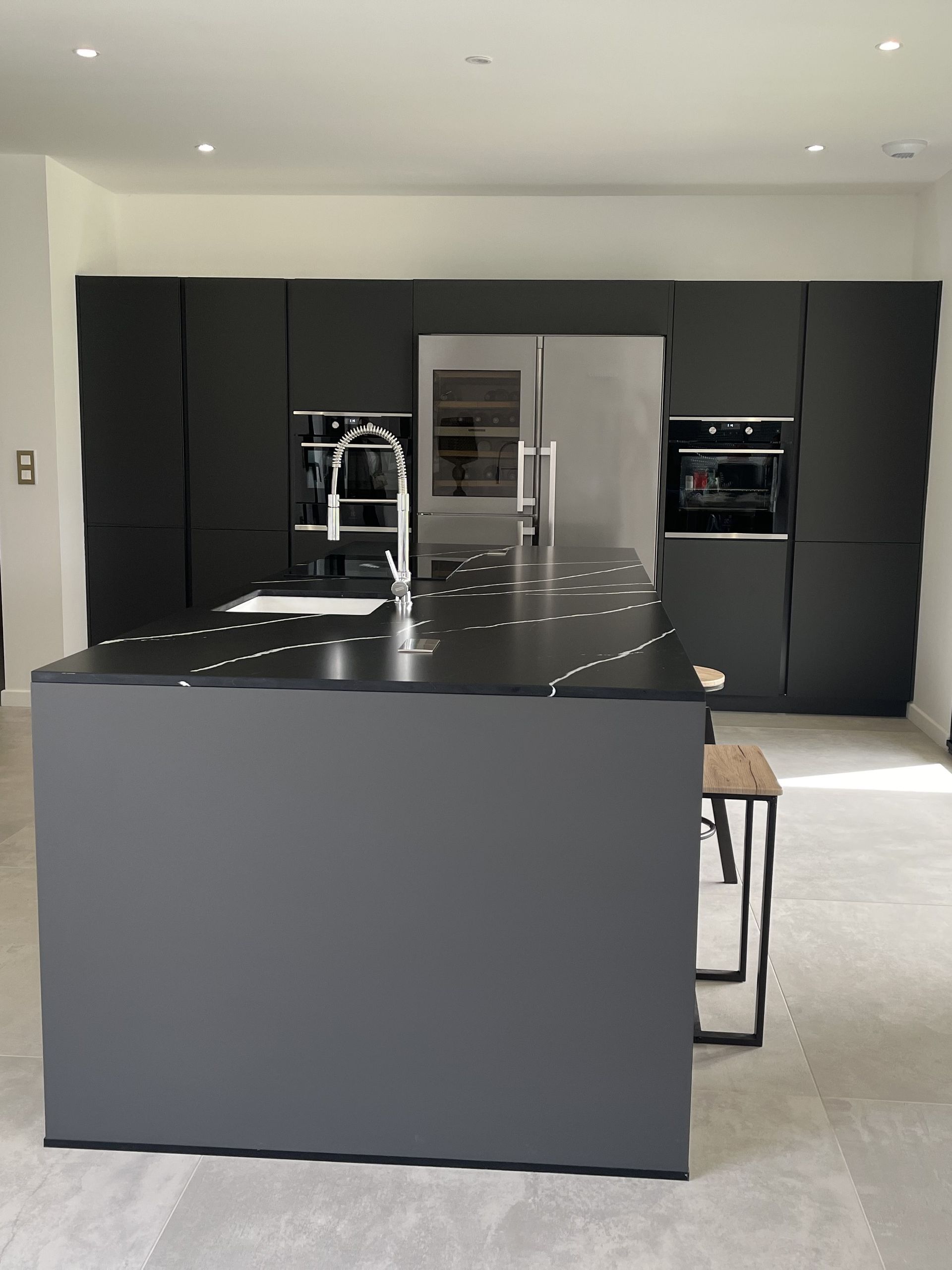 Cuisine noire avec crédence miroir et électroménager intégré