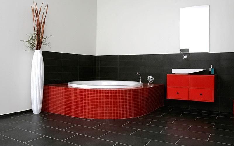 Ein Badezimmer mit einer roten Badewanne und einem roten Waschtisch