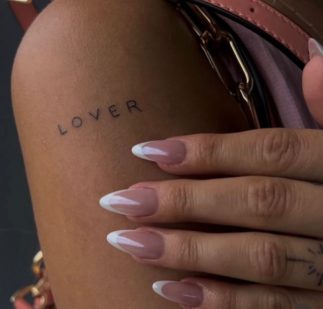 Eine Frau hat ein Tattoo auf ihrem Arm mit der Aufschrift „Liebhaber“