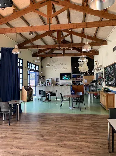 Una gran sala con vigas de madera y mesas y sillas.