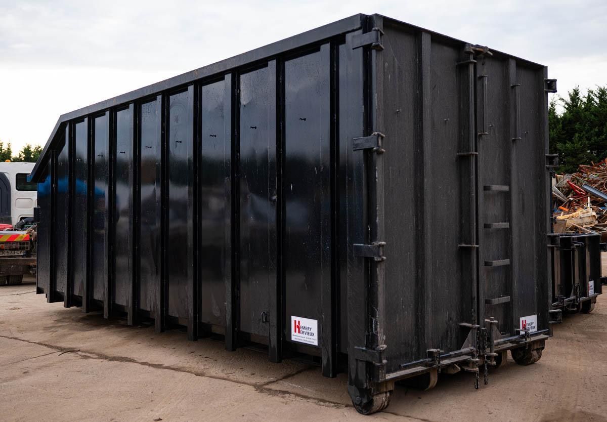 Conteneur à déchets industriels noir sur roues.