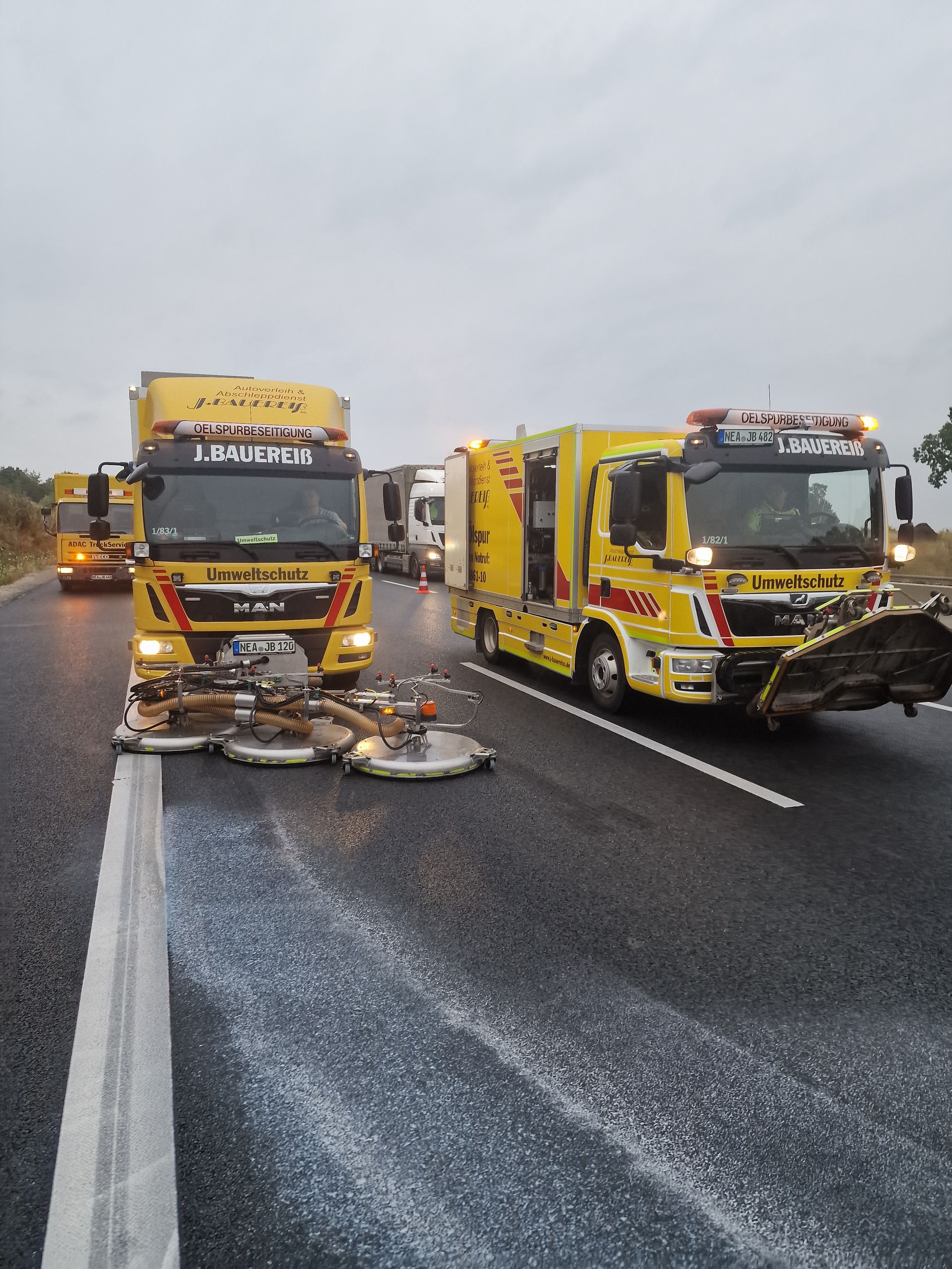 Zwei gelbe Lastwagen stehen am Straßenrand