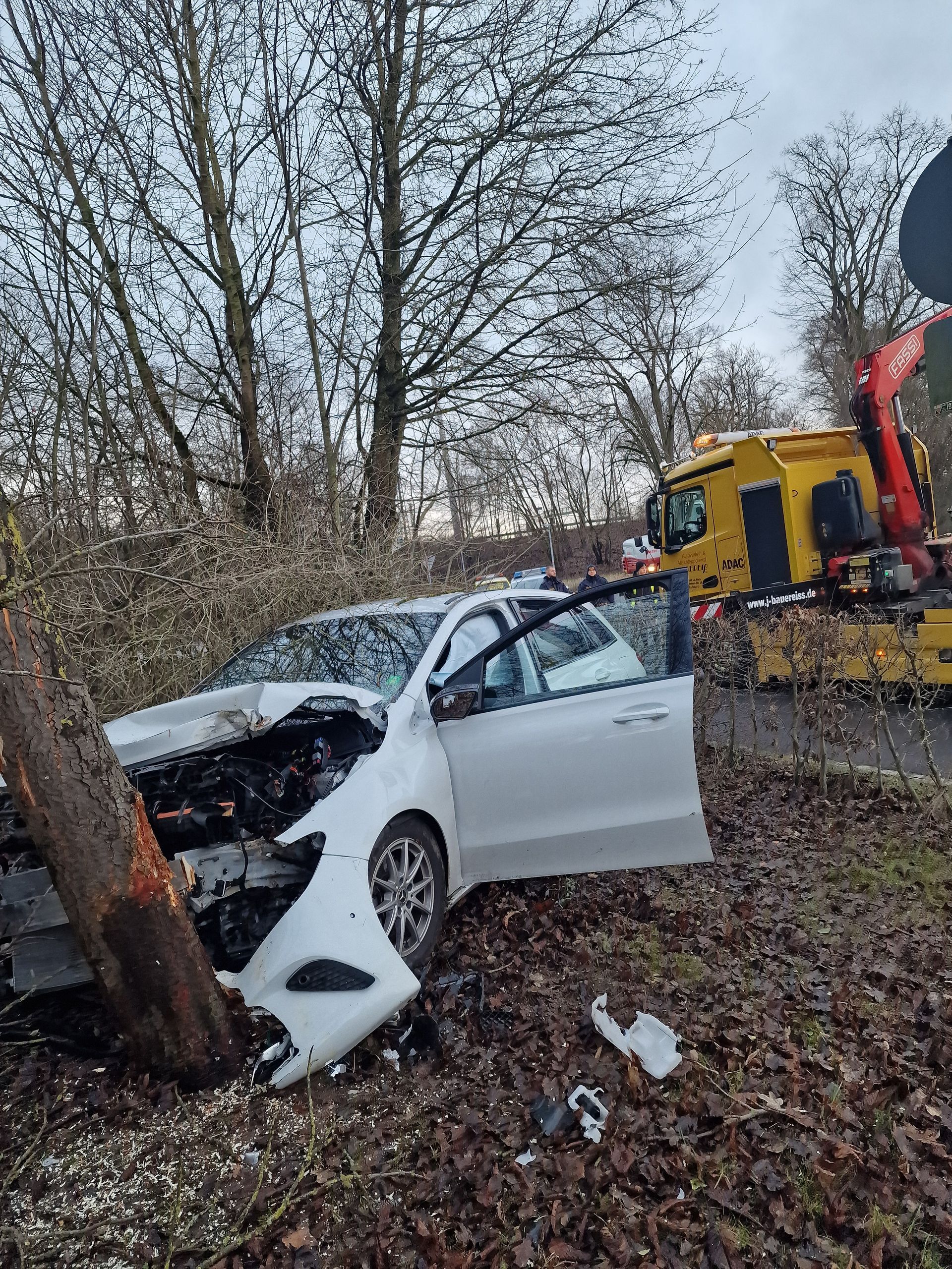 Ein Auto ist gegen einen Baum am Straßenrand geprallt.