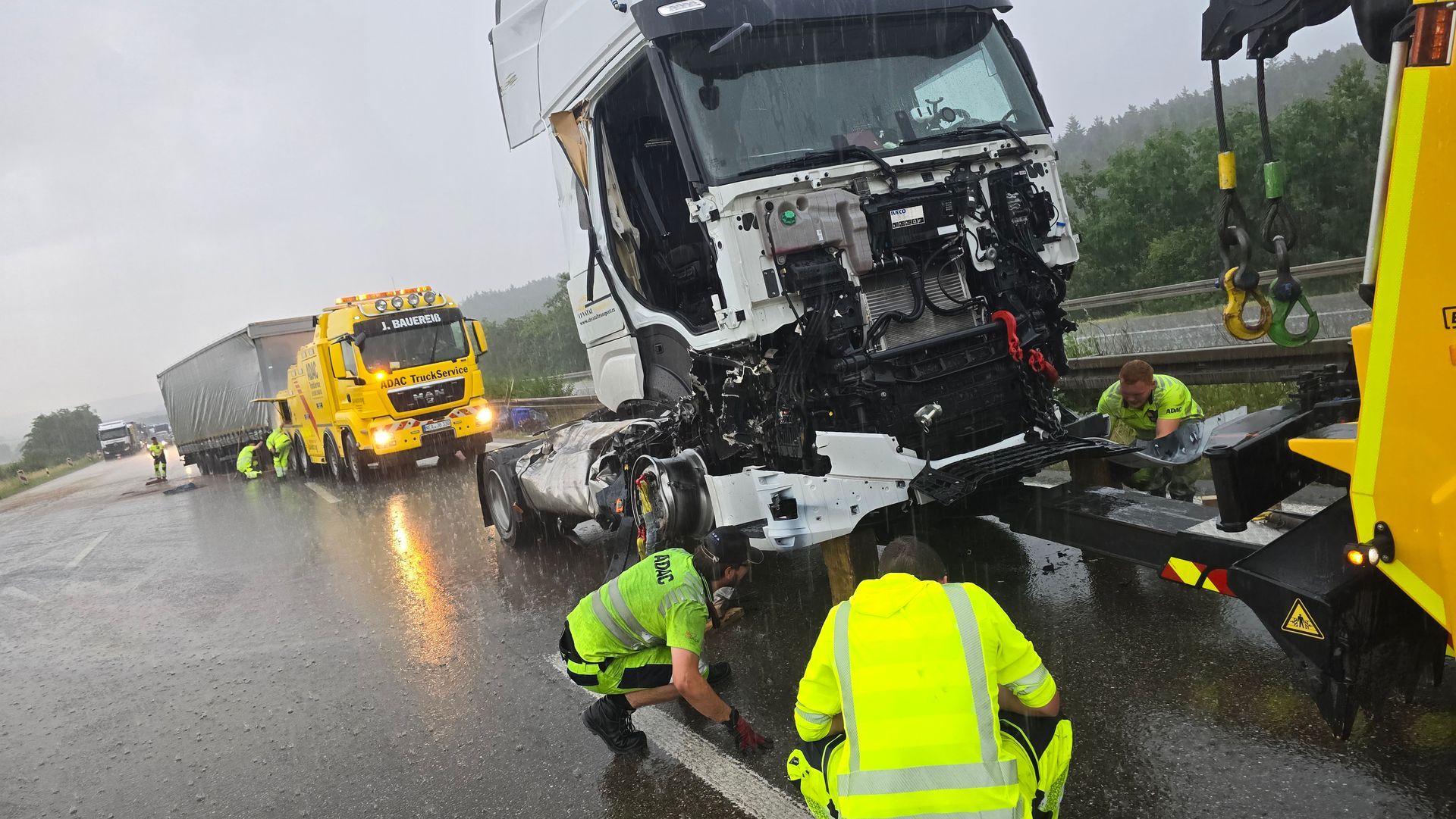 Auf einer nassen Autobahn ist ein Lastwagen mit einem anderen Lastwagen zusammengestoßen.