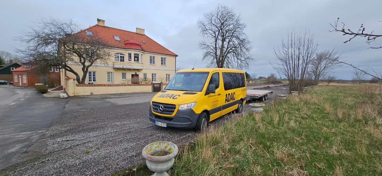 Ein gelber Lieferwagen steht vor einem Haus.