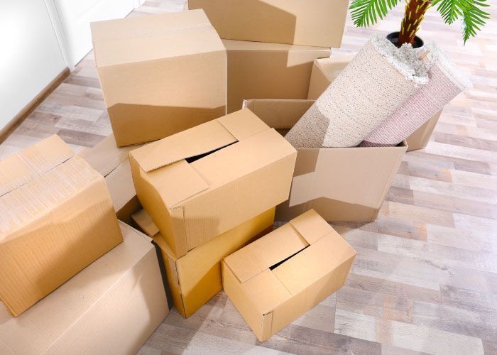 Una pila de cajas de cartón sobre un suelo de madera