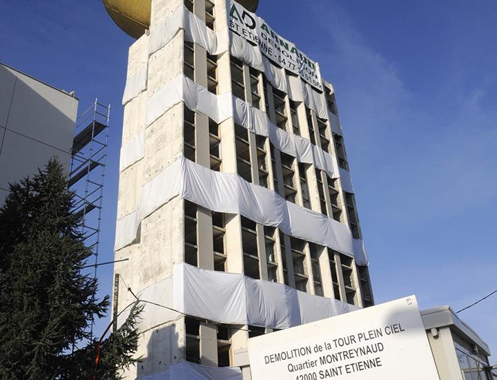 Bâtiment recouvert de bâches blanches en vue de sa démolition, avec un panneau « Démolition de la Tour Plein Ciel »