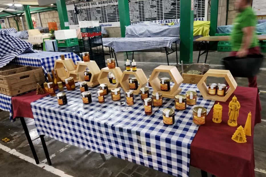 Puesto de mercado que exhibe tarros de miel en 