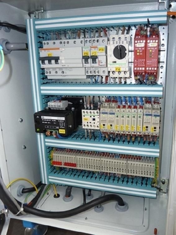 Tableau de commande électrique avec disjoncteurs, relais, câblage et borniers à l'intérieur d'une armoire métallique