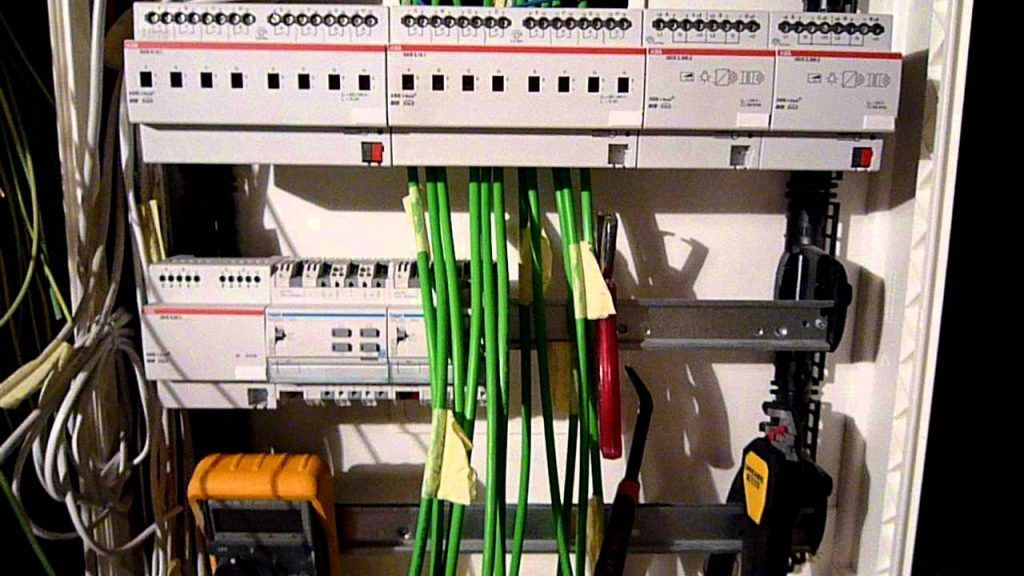 Armoire électrique/réseau ouverte contenant des panneaux de brassage, des câbles verts et du matériel de câblage.