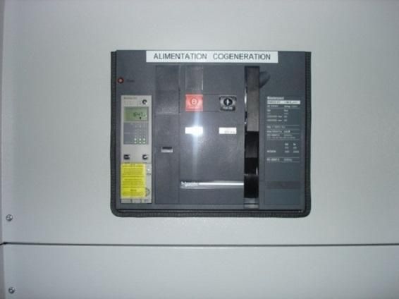 Panneau de commande électrique portant l'inscription COORINATION D'ALIMENTATION sur un mur gris avec des étiquettes d'avertissement