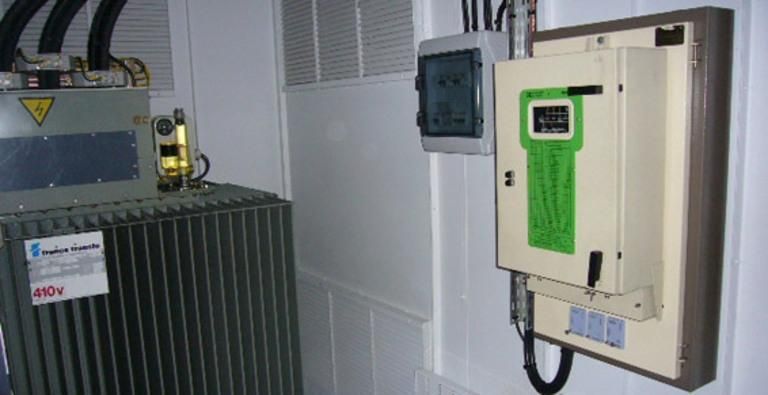 Équipements électriques industriels avec transformateur de grande taille et panneau de commande mural dans une salle des machines