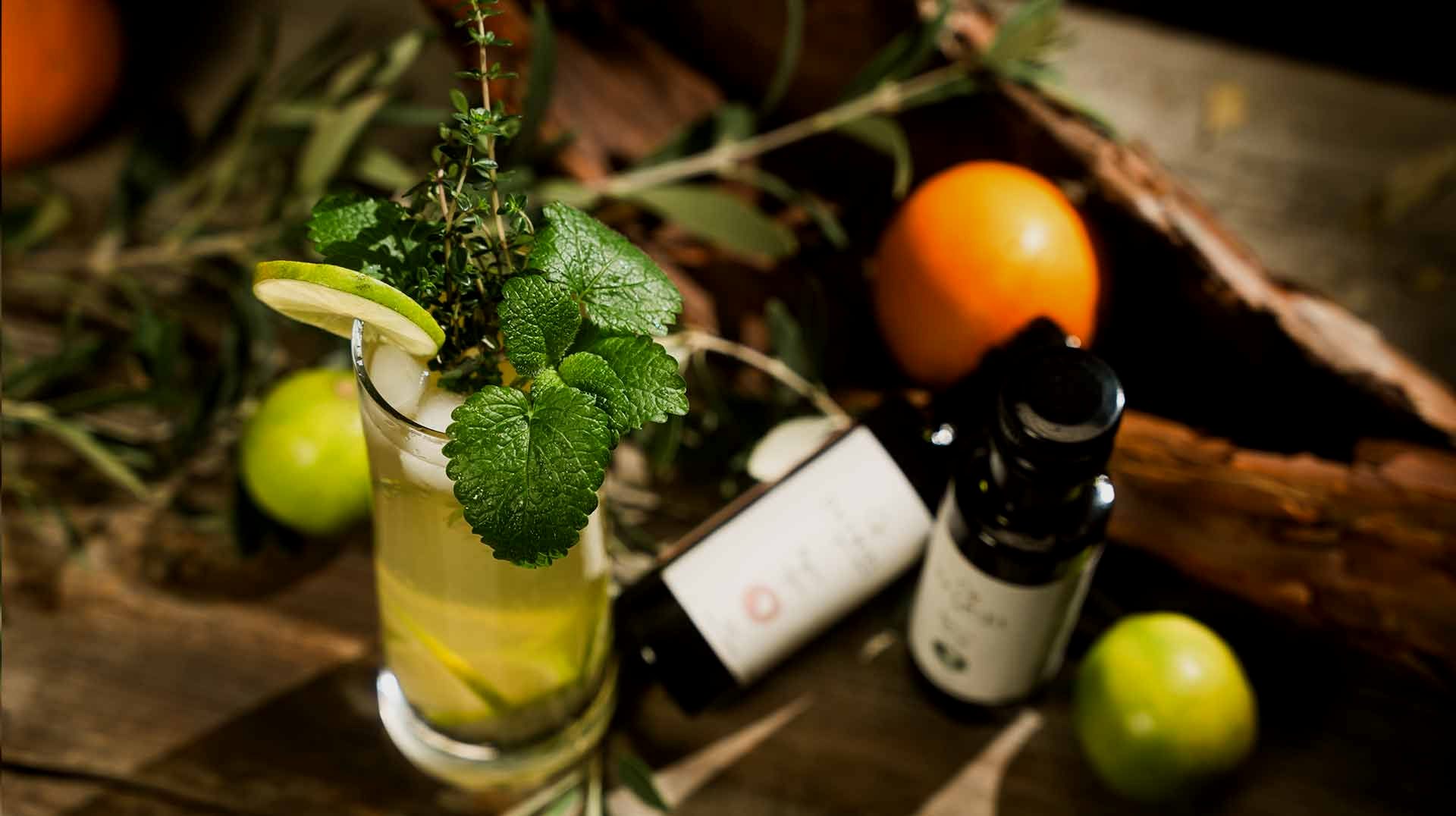 eine Flasche ätherisches Öl mit einem Zweig darauf sitzt auf einem Holztisch .