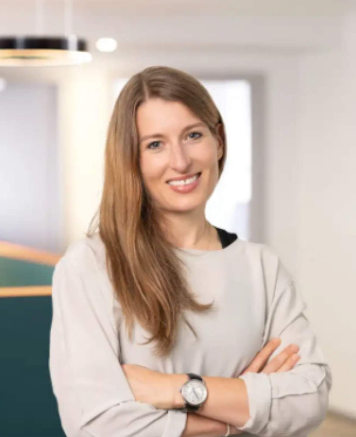 Eine Frau mit Brille und weißem Kittel lächelt in die Kamera