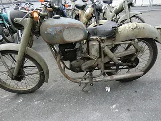 Ein altes Motorrad, ein Oltimer, steht auf einem Markt zum Anschauen und Verkaufen.