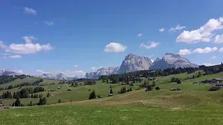 Im Hintergrund sind Berge und im Vordergrund eine Wiese.