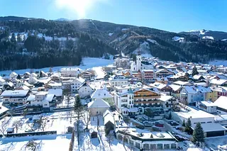 Eine Luftaufnahme einer verschneiten Stadt mit Bergen im Hintergrund