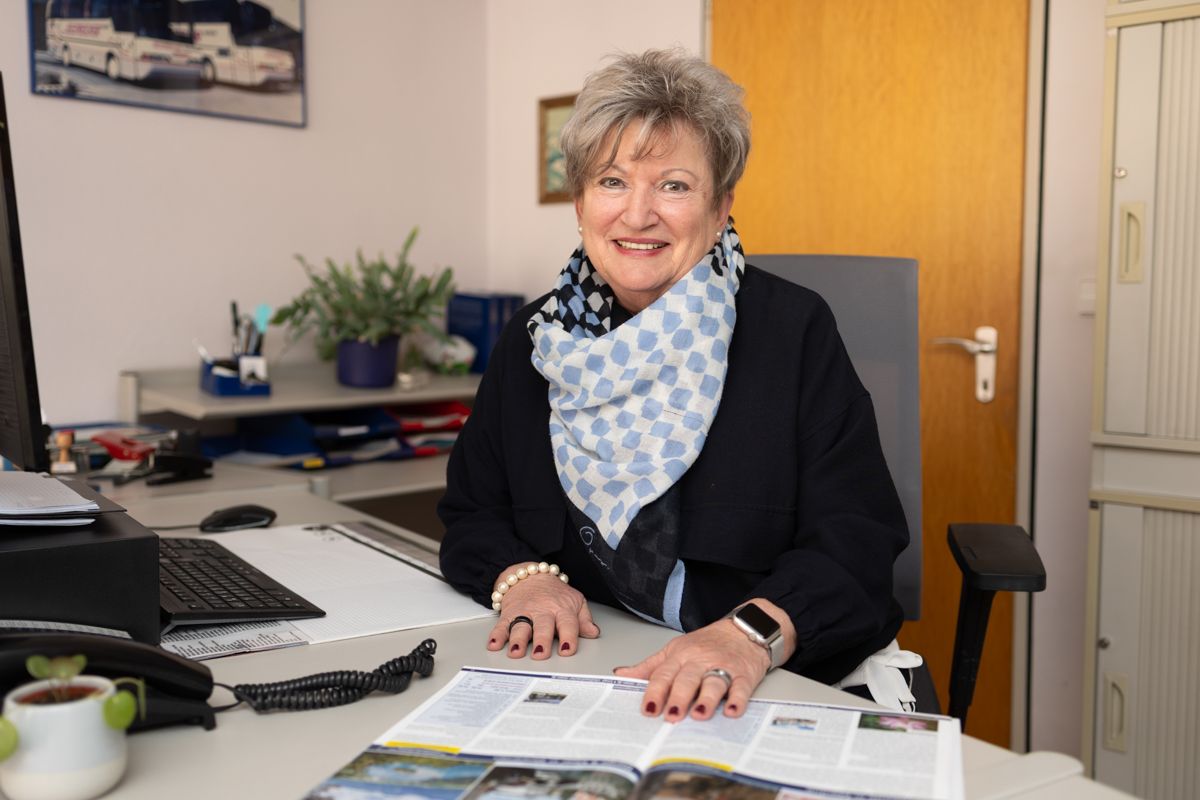 Eine Frau sitzt an einem Schreibtisch vor einem Computer.
