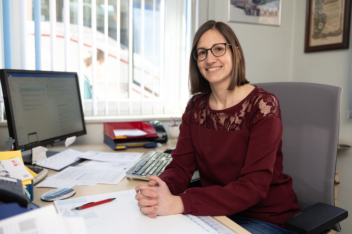 Eine Frau sitzt an einem Schreibtisch vor einem Computer.