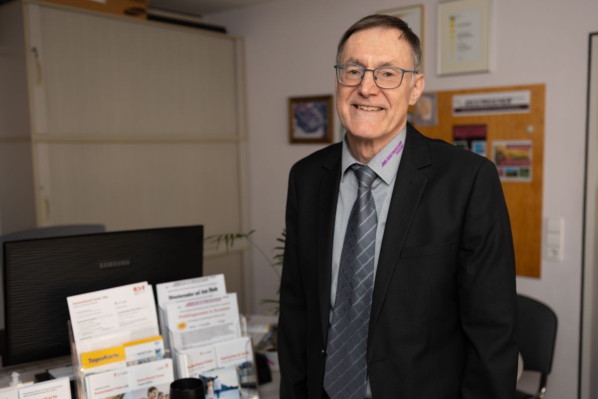 Ein Mann in Anzug und Krawatte steht in einem Büro.