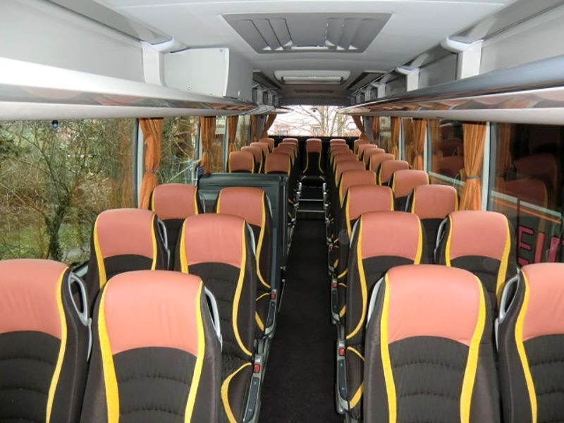 Das Innere eines Busses mit roten und gelben Sitzen