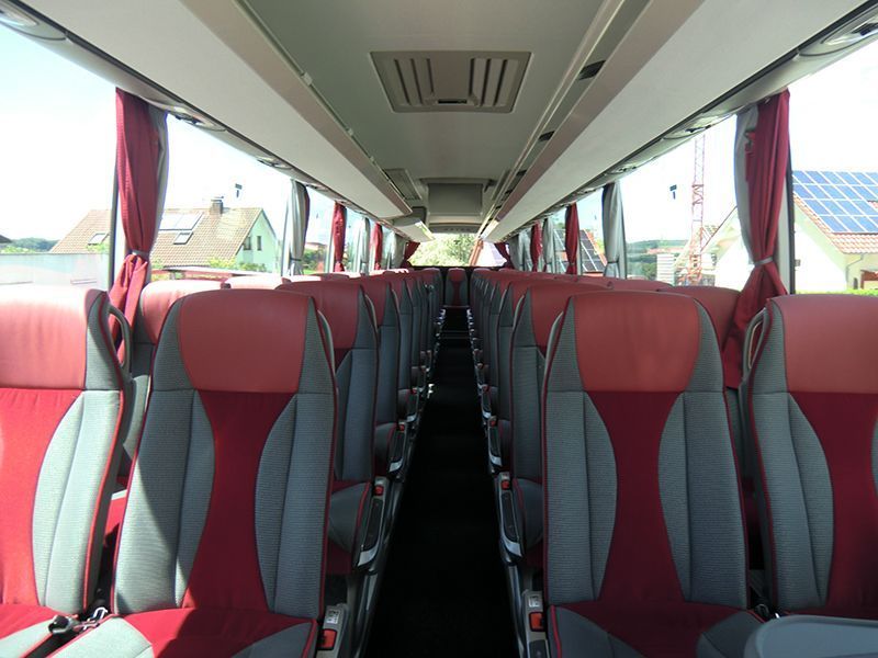 Das Innere eines Busses mit roten und grauen Sitzen