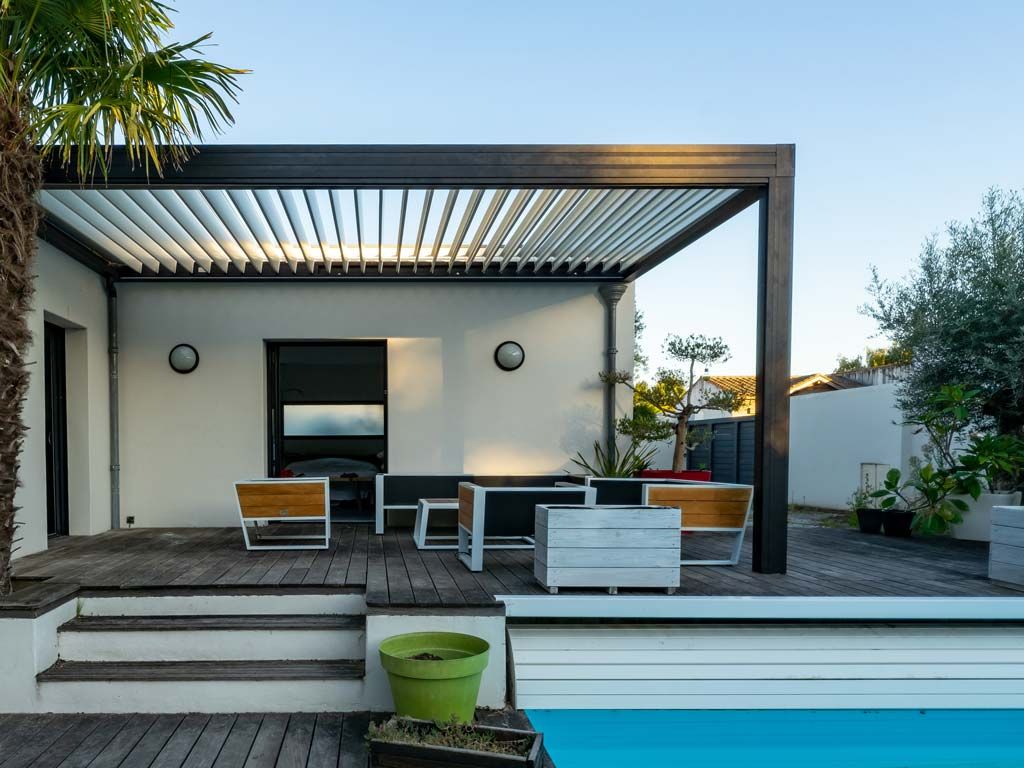Terrasse avec pergola, piscine et mobilier moderne. La lumière du soleil filtre à travers les lattes.