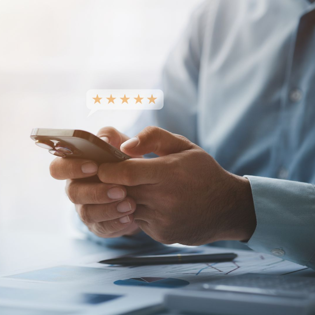 Personne tenant un téléphone, notation avec cinq étoiles, cadre de bureau, gros plan des mains.