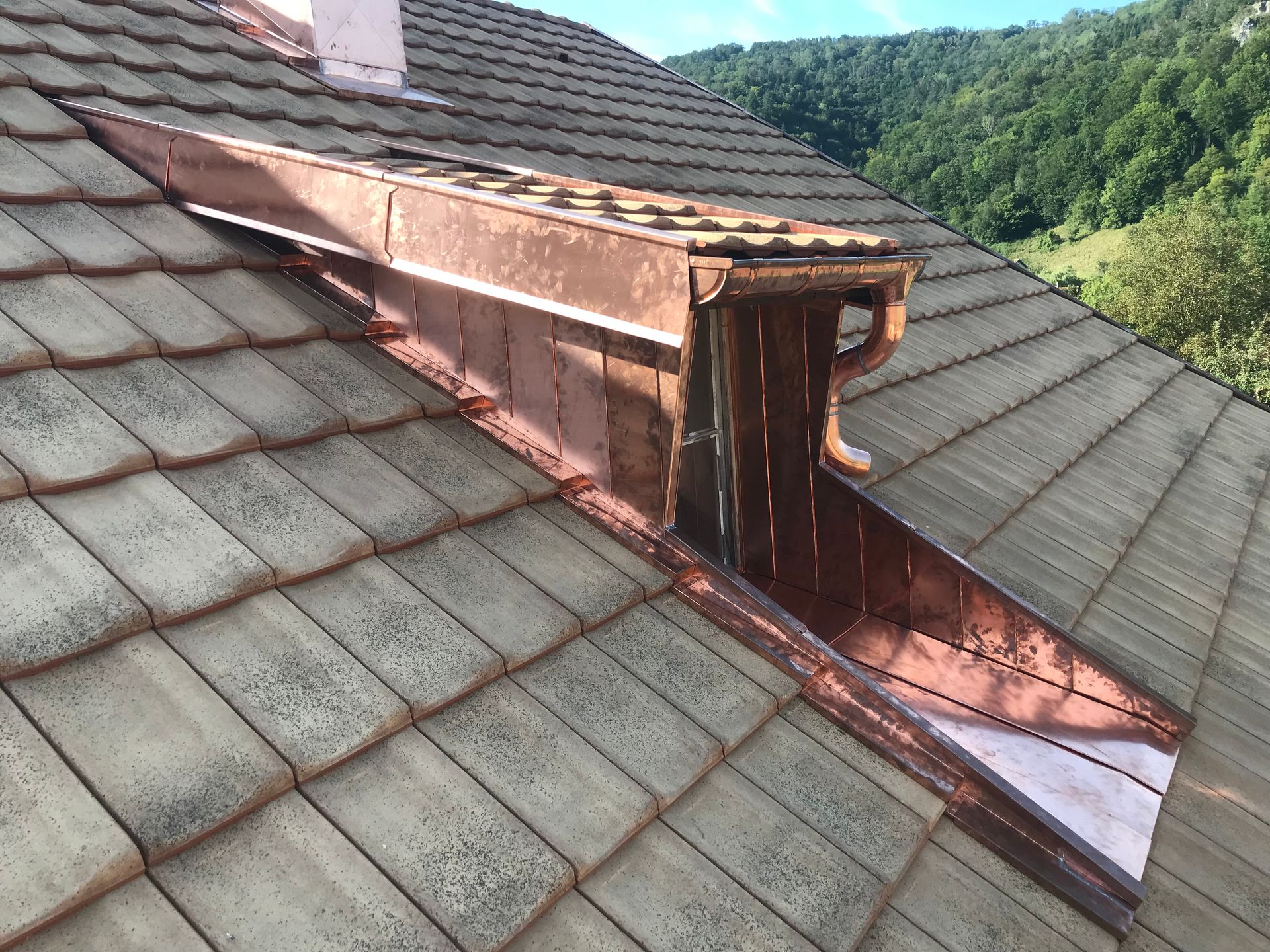Une gouttière et un tuyau de descente blancs fixés à l'angle d'une maison d'habitation avec un revêtement bleu et des garnitures blanches.