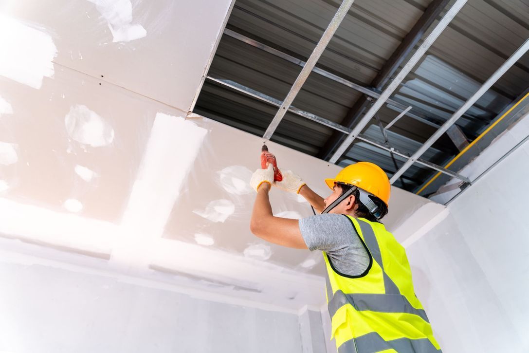 Un trabajador de la construcción está trabajando en el techo de una habitación.