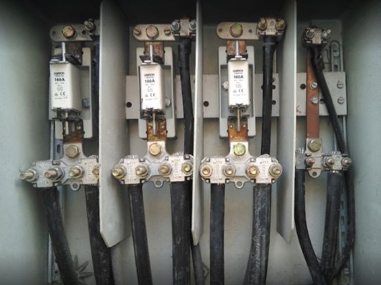 Un primer plano de una caja eléctrica con cables y fusibles.