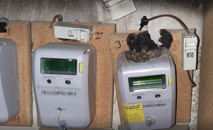 Un montón de medidores eléctricos están colocados en una pared.