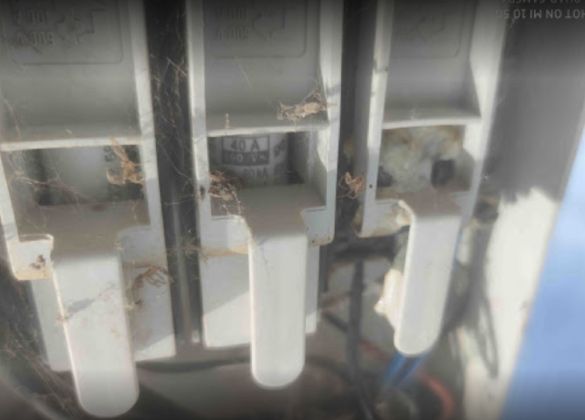 Un primer plano de una caja eléctrica sucia con muchos cables saliendo de ella.