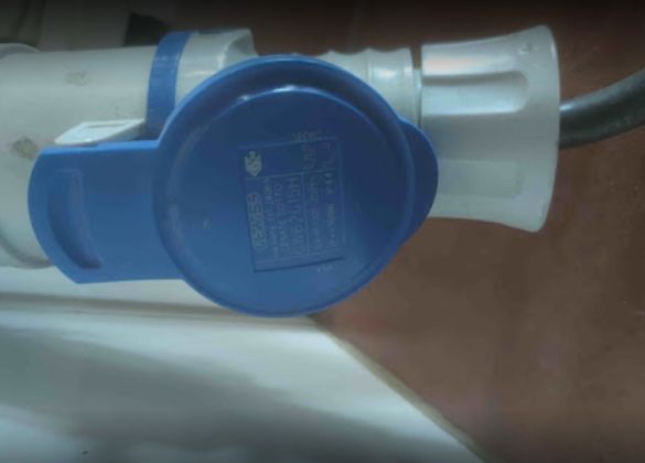 Un enchufe azul y blanco está conectado a un cable de alimentación.