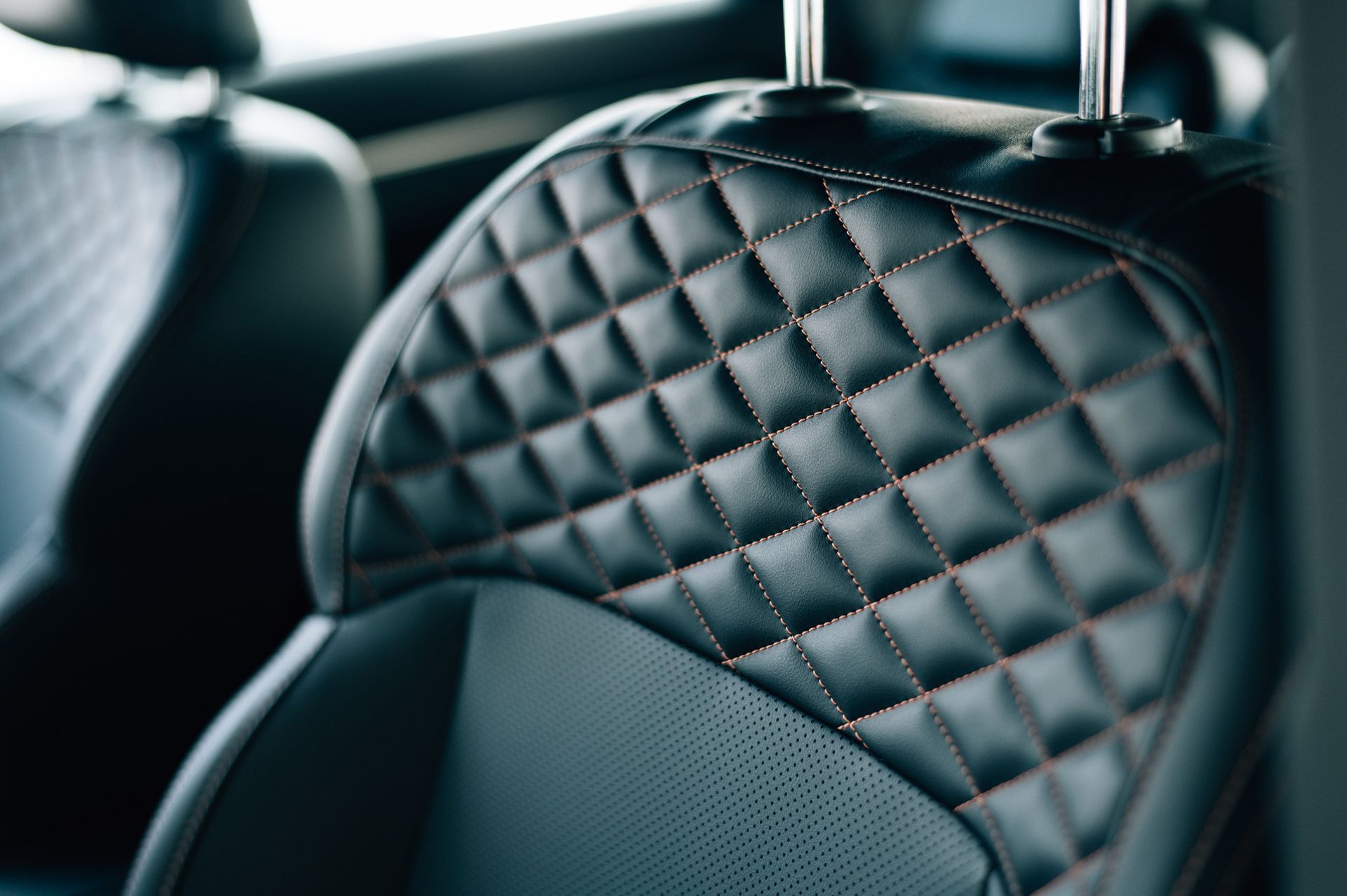 Un primer plano de un asiento de cuero acolchado en un automóvil.