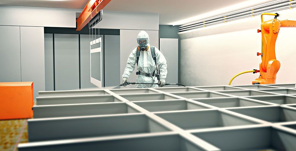 Ein Lackierer im Schutzanzug steht in einem Raum.